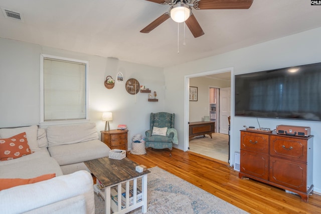 living room featuring light hardwood / wood-style flooring and ceiling fan