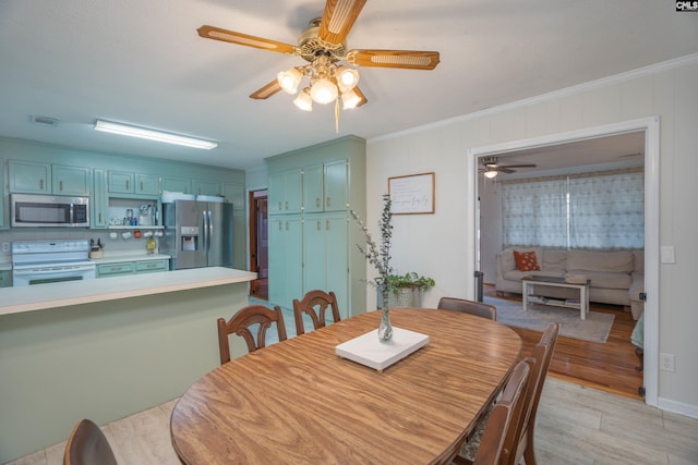 dining space with ceiling fan, light hardwood / wood-style flooring, and crown molding