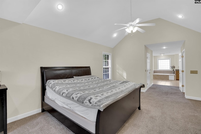 carpeted bedroom with vaulted ceiling, ceiling fan, and ensuite bathroom