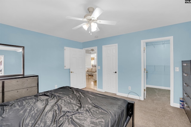 carpeted bedroom featuring a spacious closet, ceiling fan, and a closet