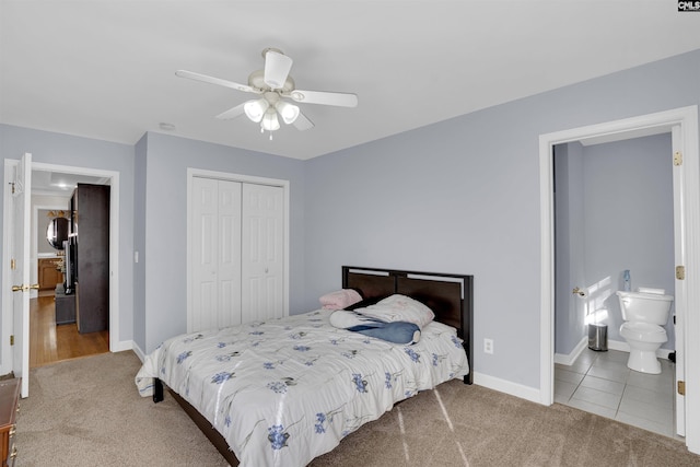 carpeted bedroom featuring a closet, ceiling fan, and ensuite bathroom