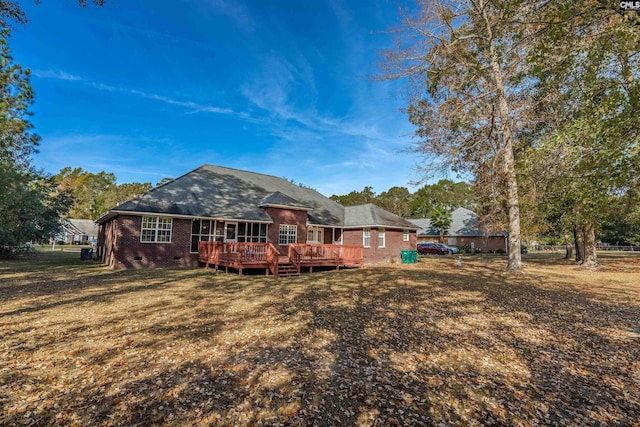 back of property featuring a lawn and a wooden deck