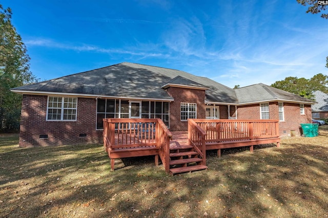 back of property with a wooden deck, a lawn, and a sunroom