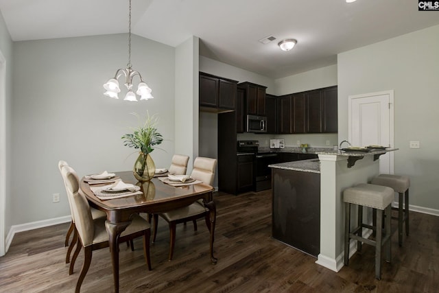 kitchen featuring dark hardwood / wood-style flooring, light stone countertops, lofted ceiling, and stainless steel appliances