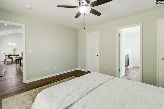 bedroom with hardwood / wood-style floors, ensuite bath, ceiling fan, and vaulted ceiling