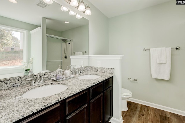 bathroom with toilet, vanity, hardwood / wood-style flooring, and a shower with door