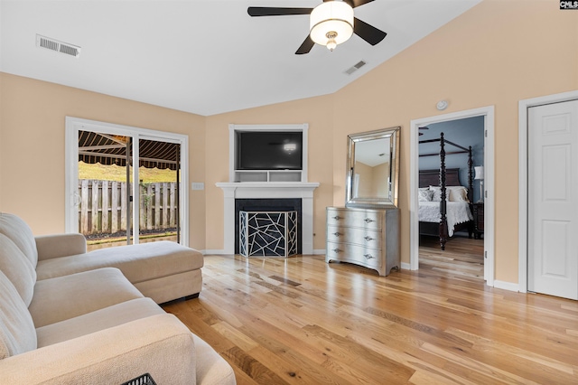 living room featuring lofted ceiling, ceiling fan, and light hardwood / wood-style flooring