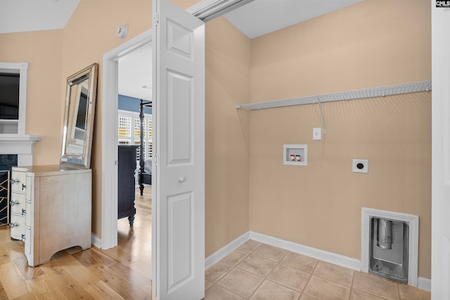 laundry area with light wood-type flooring, washer hookup, a fireplace, and electric dryer hookup