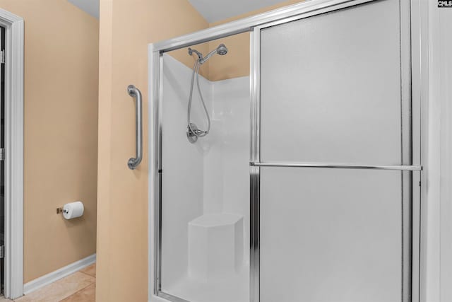 bathroom with tile patterned floors and a shower with door