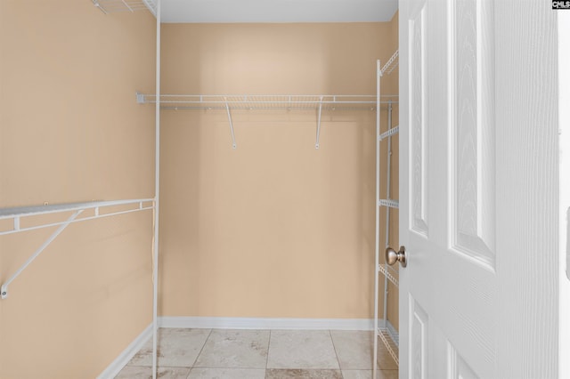 walk in closet with light tile patterned floors