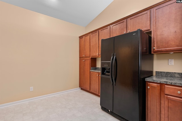 kitchen with black refrigerator with ice dispenser, built in desk, and lofted ceiling