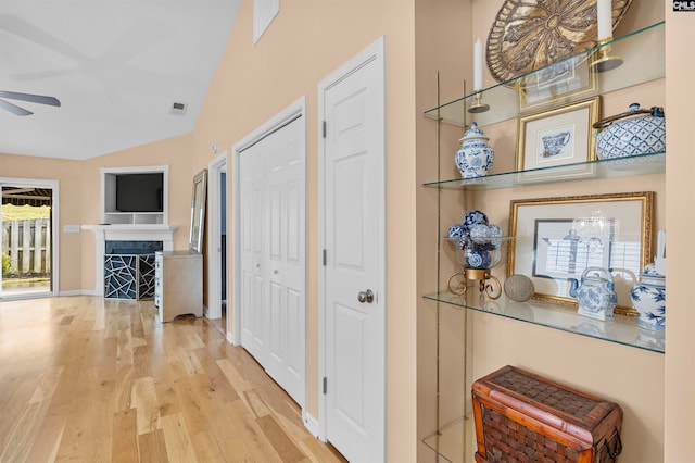 hallway with lofted ceiling and hardwood / wood-style flooring