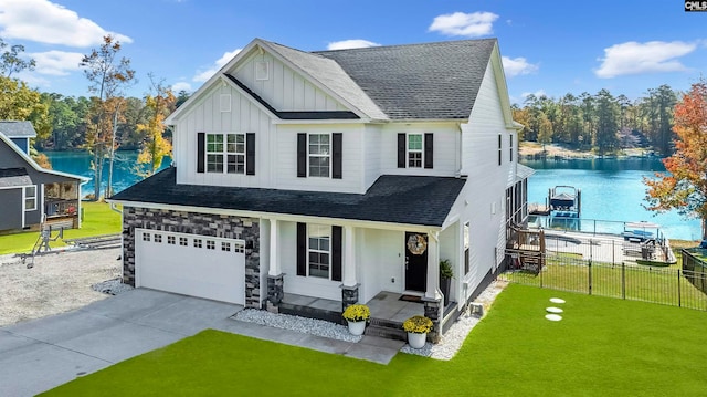 view of front of house featuring a front lawn, a garage, and a water view