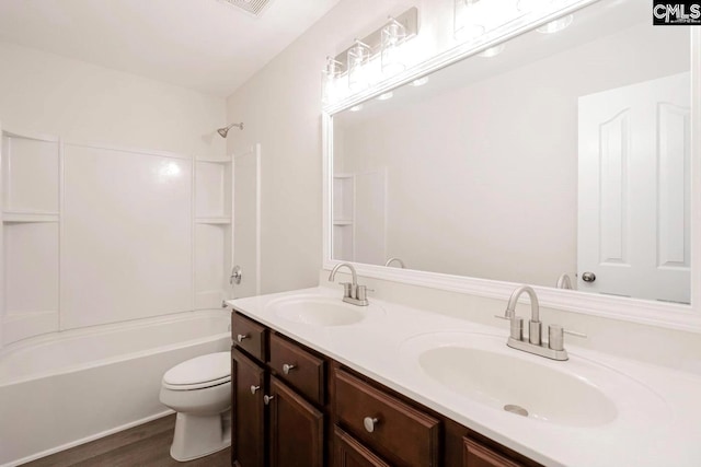 full bathroom with vanity, hardwood / wood-style floors, washtub / shower combination, and toilet