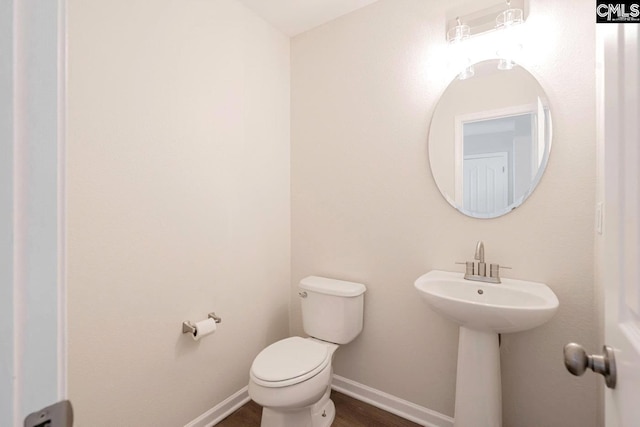 bathroom featuring hardwood / wood-style flooring and toilet