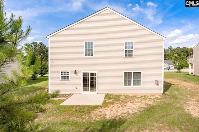 rear view of house with a lawn and a patio area