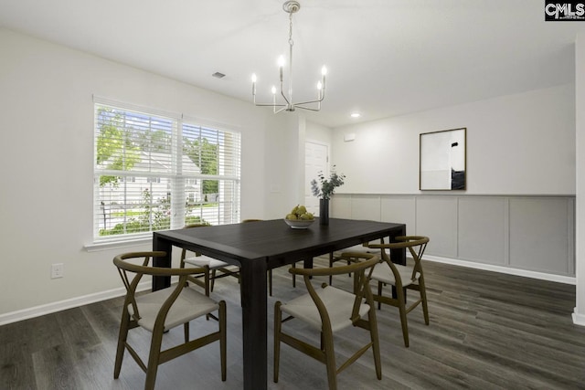 dining room with dark hardwood / wood-style floors and an inviting chandelier