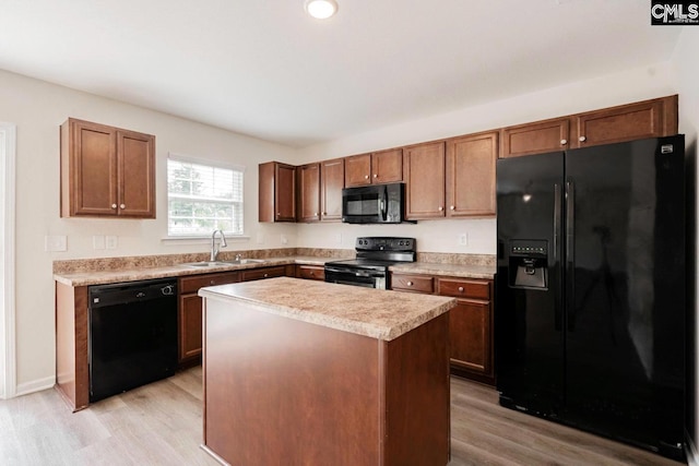 kitchen featuring sink, a center island, black appliances, and light hardwood / wood-style floors