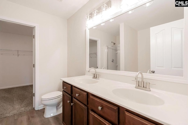 bathroom with toilet, vanity, an enclosed shower, and hardwood / wood-style flooring