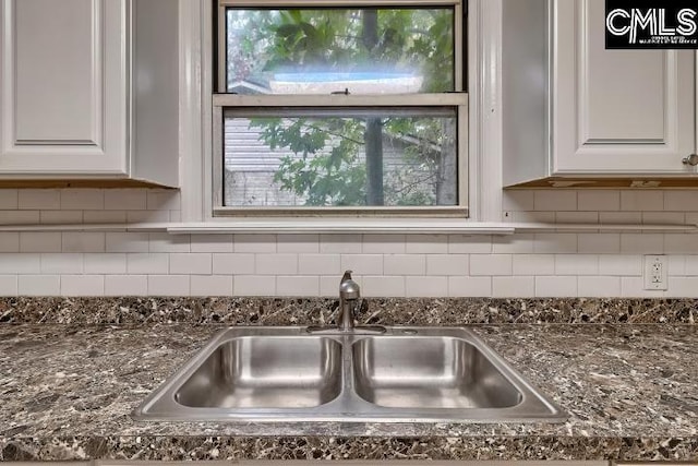 2230 Corning Rd, Columbia, SC 29205 - kitchen view of a sink, white cabinets, dark stone countertops, and backsplash