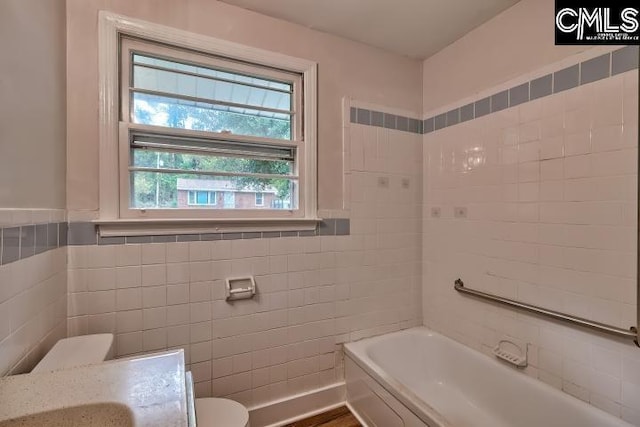 2230 Corning Rd, Columbia, SC 29205 - bathroom with tile walls, toilet, a bath, and a wainscoted wall