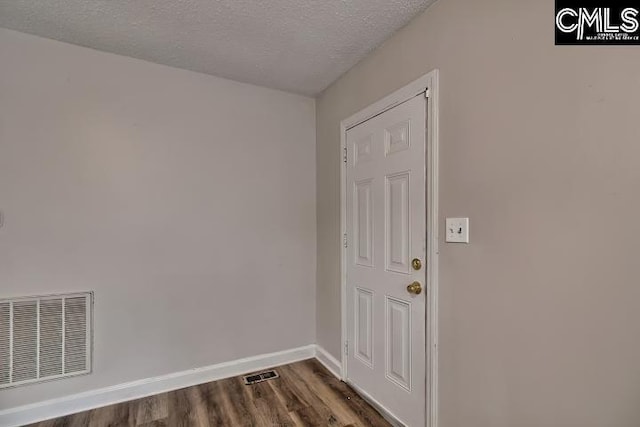 2230 Corning Rd, Columbia, SC 29205 - doorway featuring dark wood-type flooring, a textured ceiling, and baseboards