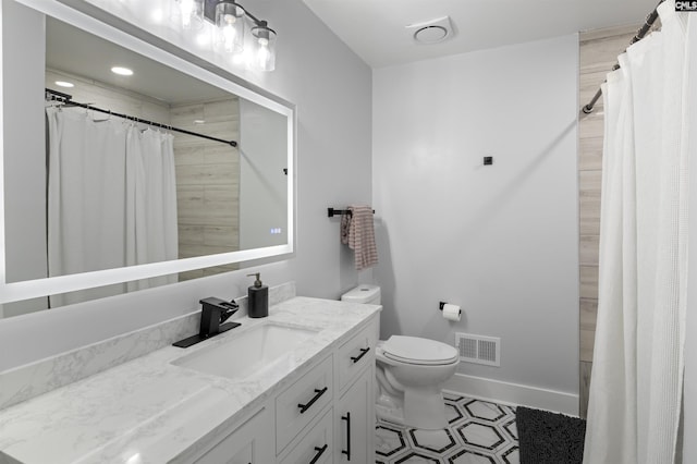 bathroom with a shower with shower curtain, tile patterned floors, vanity, and toilet