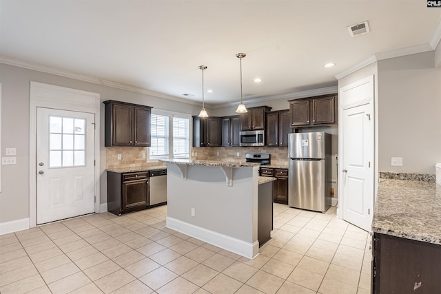 kitchen featuring stainless steel appliances, dark brown cabinetry, hanging light fixtures, crown molding, and a breakfast bar