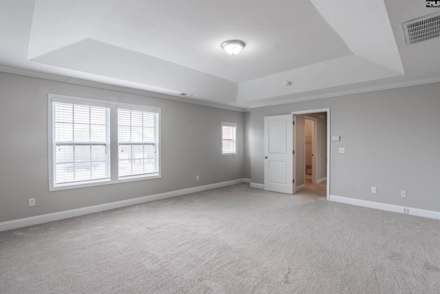 carpeted empty room with a tray ceiling and crown molding