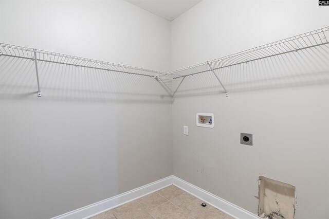 clothes washing area featuring light tile patterned floors, hookup for a washing machine, and hookup for an electric dryer