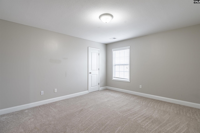 carpeted spare room featuring a textured ceiling