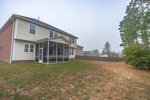 back of house with a lawn and a sunroom