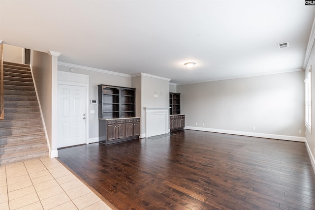 unfurnished living room featuring wood-type flooring and ornamental molding