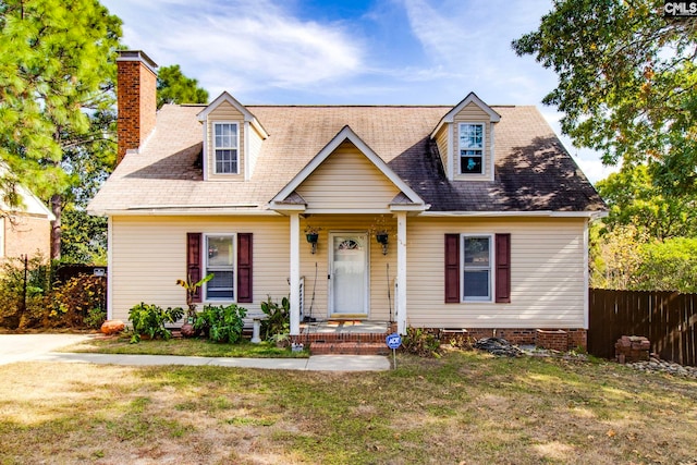 cape cod home featuring a front lawn