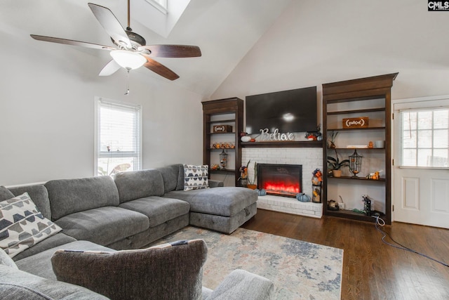 living room featuring a brick fireplace, high vaulted ceiling, dark wood-type flooring, and ceiling fan