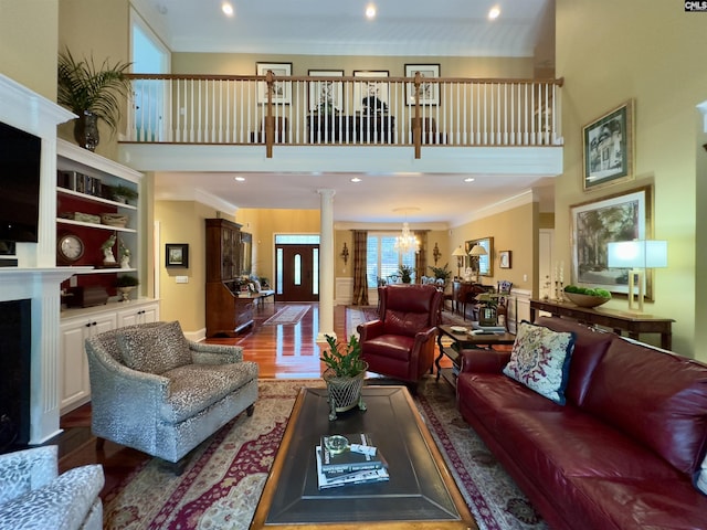 345 Old Wood Dr, Columbia, SC 29212 - living room featuring a high ceiling, crown molding, wood finished floors, a fireplace, and ornate columns