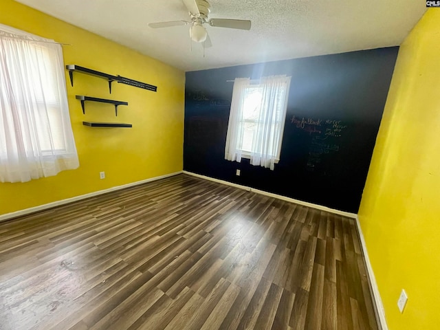 unfurnished room featuring ceiling fan, a textured ceiling, and dark hardwood / wood-style flooring