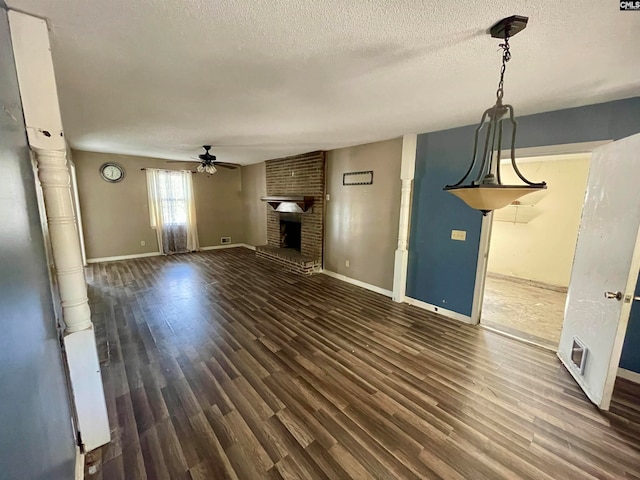 unfurnished living room with a fireplace, dark hardwood / wood-style floors, a textured ceiling, and ceiling fan