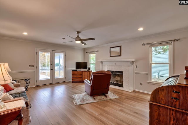 living room with ornamental molding, light wood-type flooring, a wealth of natural light, and ceiling fan