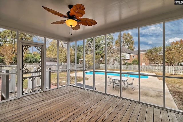 unfurnished sunroom with ceiling fan