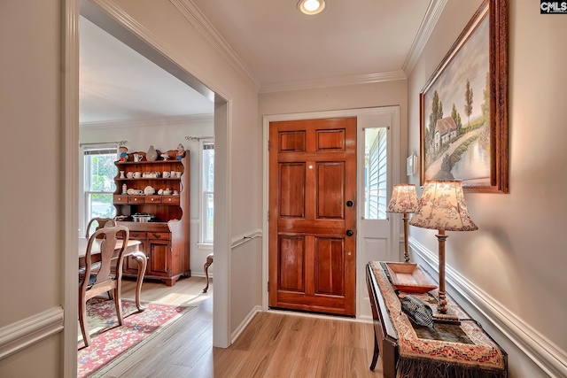 foyer featuring ornamental molding and light hardwood / wood-style flooring