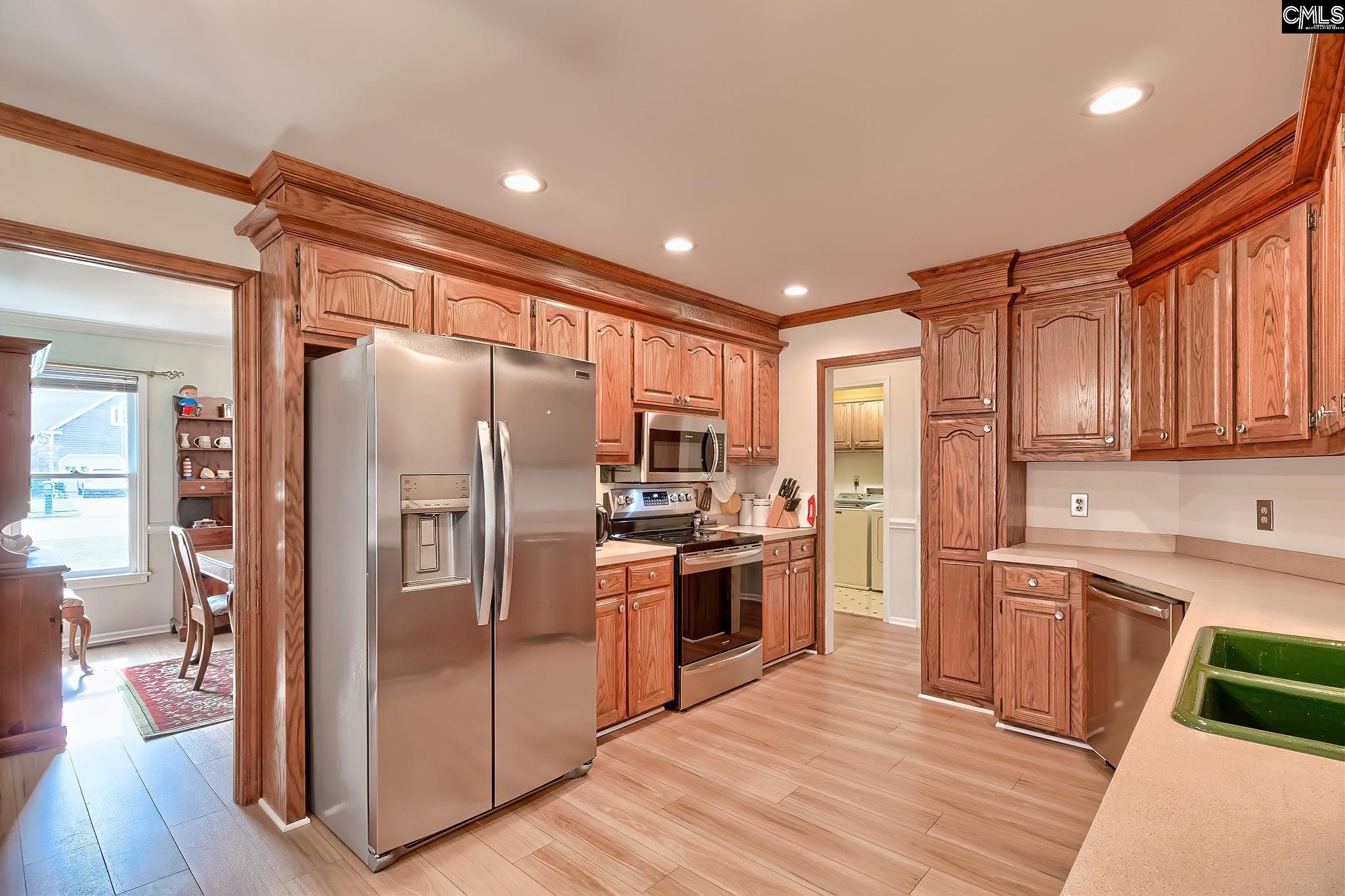 kitchen featuring separate washer and dryer, crown molding, light hardwood / wood-style floors, and stainless steel appliances