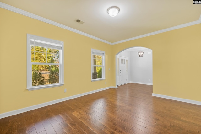 spare room featuring ornamental molding, hardwood / wood-style floors, and a notable chandelier