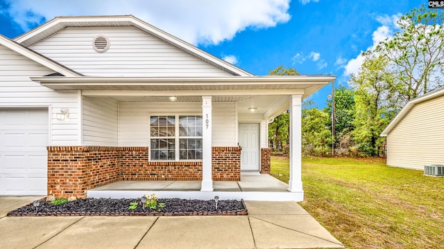 property entrance with a garage, central air condition unit, a lawn, and a porch