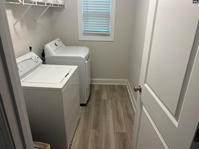 washroom with washer and dryer and light hardwood / wood-style flooring