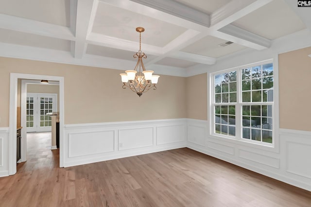 unfurnished dining area with light hardwood / wood-style flooring, beamed ceiling, a chandelier, and coffered ceiling