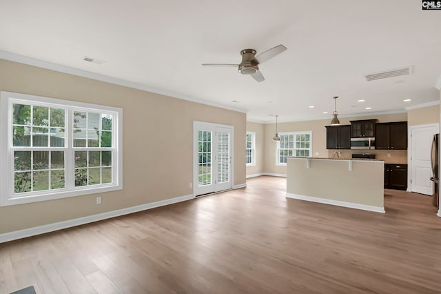 unfurnished living room featuring ceiling fan, light wood-type flooring, and ornamental molding