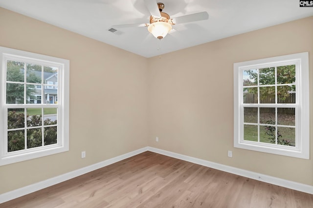 empty room featuring light wood-type flooring, ceiling fan, and plenty of natural light