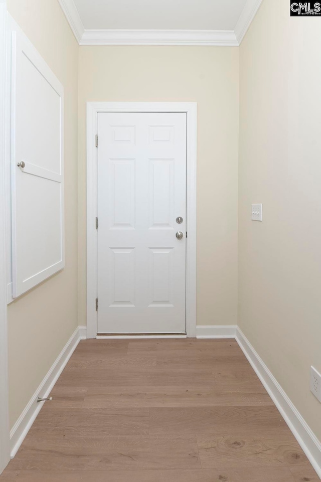 doorway with ornamental molding and light hardwood / wood-style flooring