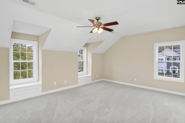 additional living space with light colored carpet, ceiling fan, and vaulted ceiling